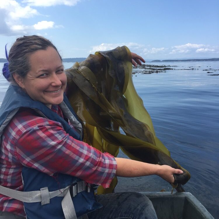 woman holding seaweed on floating boat