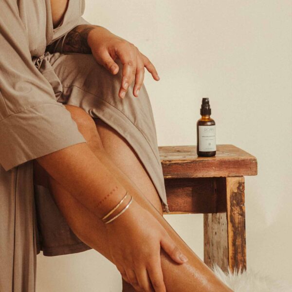 Woman applying oil on legs