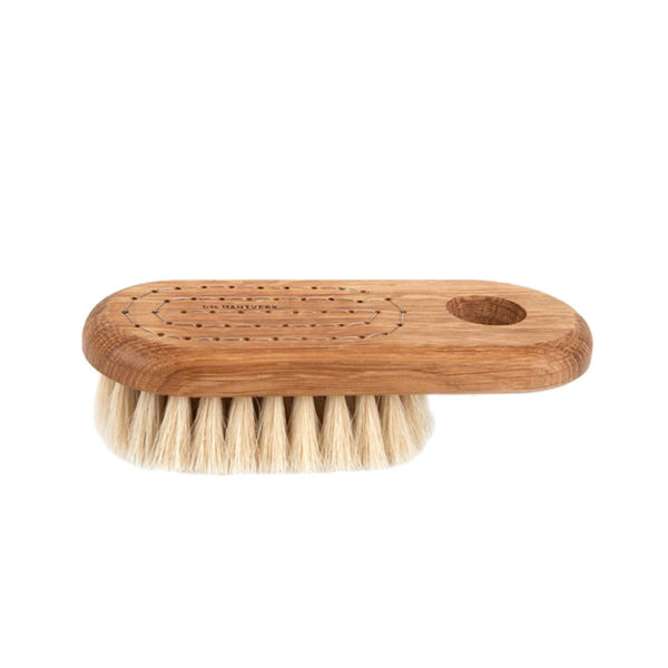 bath brush with handle on white surface