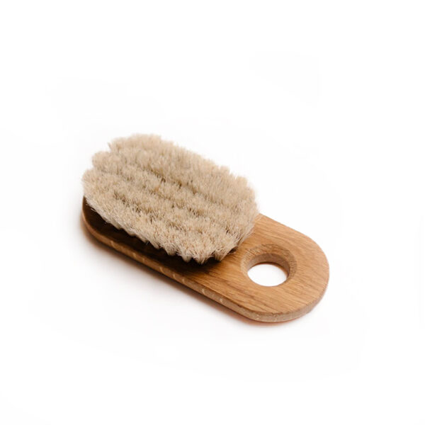bath brush with handle on white surface