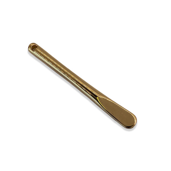 gold color steel cosmetic spatula on white surface