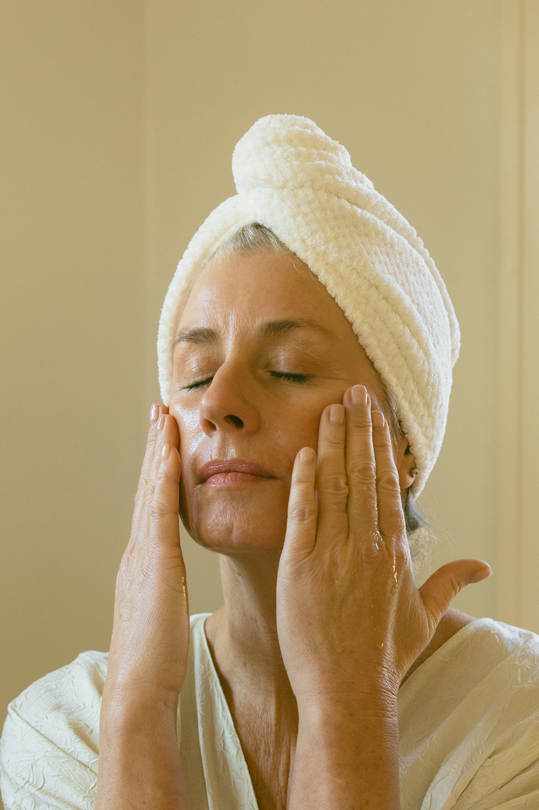 Transition your skincare routine — dewy spring skin close-up, pressing sunrise oil into the skin