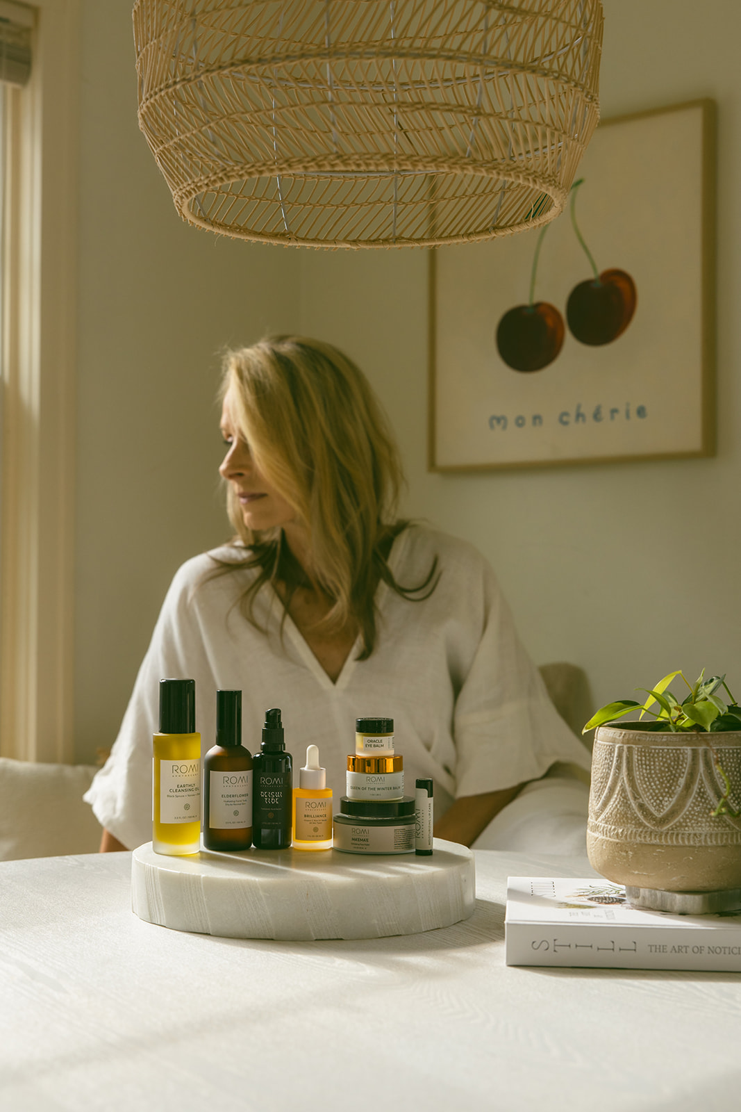 Transition your skincare routine — ROMI products in fresh spring light, with a woman at ease in the background