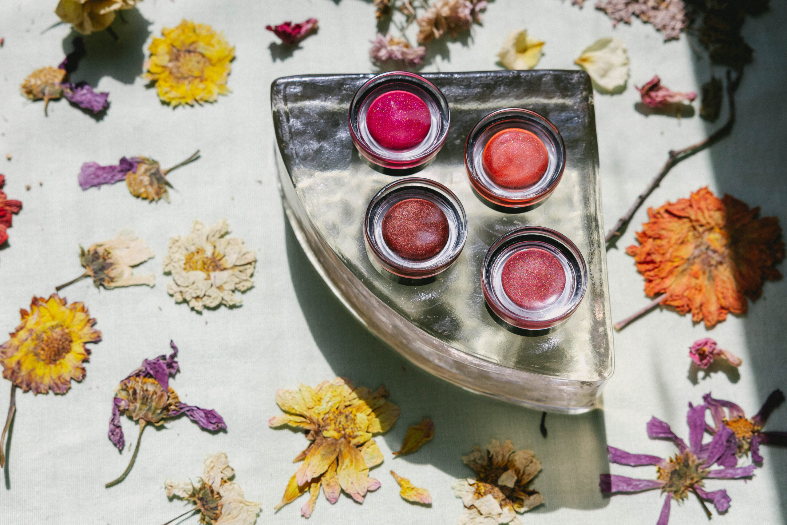 All four Lip Tint shades arranged together with fresh spring florals, joyful and abundant